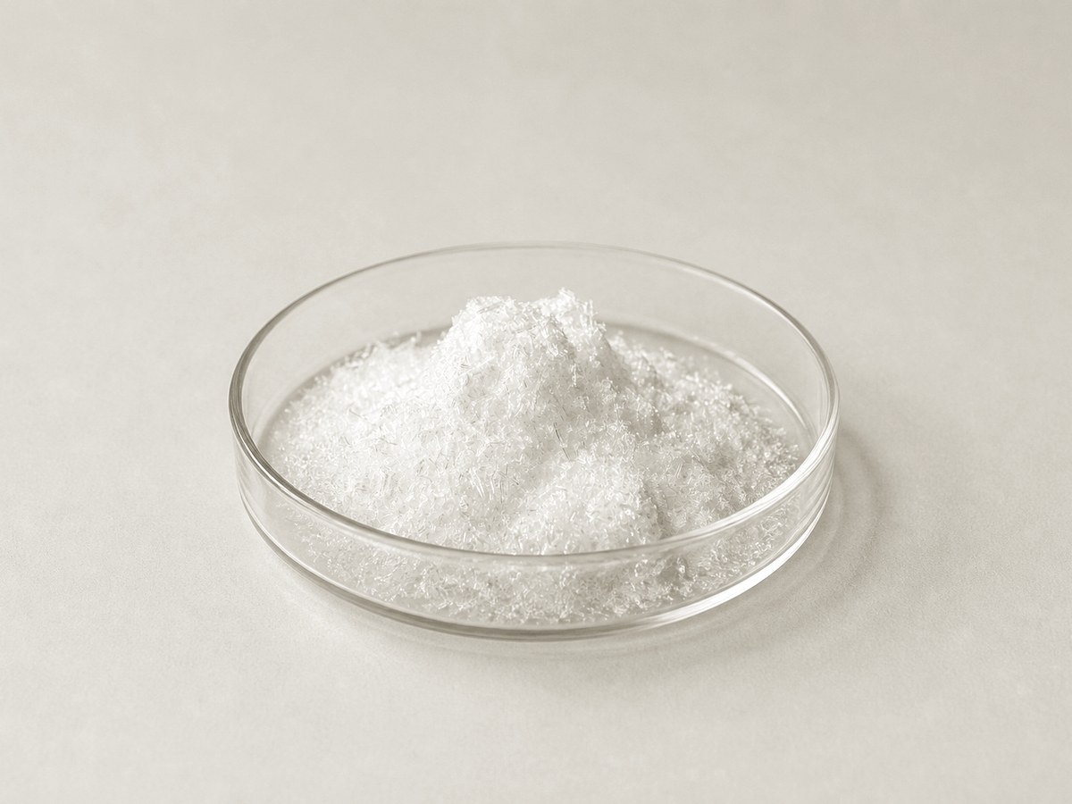 White crystalline taurine powder in a glass petri dish